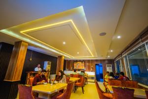 a group of people sitting at tables in a restaurant at THE SEASHORE HOTEL in Kanyakumari