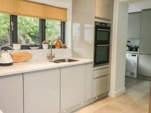 a kitchen with white cabinets and a sink at Trevonnen in Llyswen