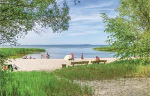 a group of people sitting on the beach at One-Bedroom Holiday Home In Bellin in Bellin