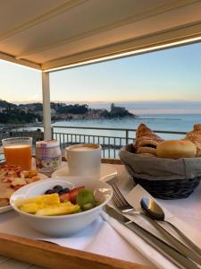 a table with a plate of food with a view of the ocean at Hotel Florida Lerici in Lerici