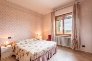 a bedroom with a bed and a window at Tenuta Fornacelle La Rosa in San Gimignano +18 photos