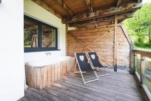a bathroom with two chairs and a tub on a deck at AvenidA Panorama Suites in Kaprun