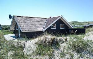 a small black house on the beach at Holiday Home Hvide Sande 20 in Bjerregård