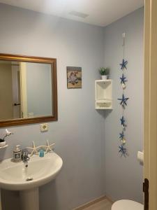 a bathroom with a sink and a mirror and a toilet at Ático duplex Lagos del Castillo in Denia +24 photos
