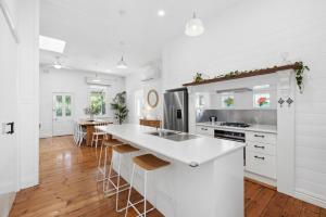 a kitchen with white cabinets and a white counter top at Charming Heritage Haven 'Ye Olde St Leonards Hotel' 3 Bedroom, Pet Friendly, Fire Place, Free Wifi & Netflix, Walk to Beach & Shops in Saint Leonards
