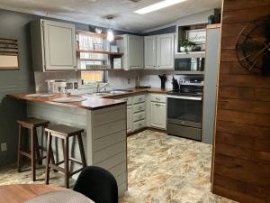 a kitchen with white cabinets and a counter with stools at Auburn in Chester