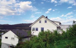 a white house sitting on top of a hill at Cozy Apartment In Fitjar in Fitjar