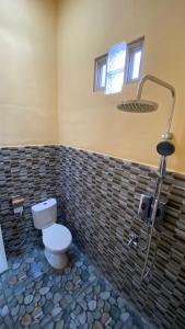 un baño con inodoro y ducha en Luchis HOME Ijen, en Banyuwangi