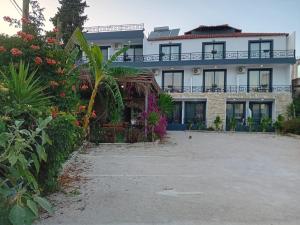 a large white building with a lot of plants at Villa Allkushi in Sarandë