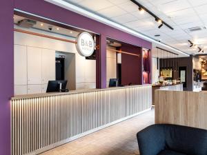 a bar in a restaurant with purple walls at B&B Hotel Hamburg-Airport in Hamburg