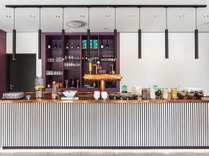 a bar in a restaurant with a counter top at B&B Hotel Hamburg-Airport in Hamburg