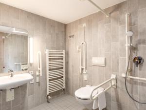 a bathroom with a toilet and a sink at B&B Hotel Hamburg-Airport in Hamburg