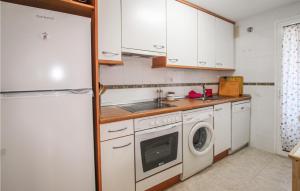 a kitchen with a white refrigerator and a washing machine at Nice Apartment In Mont-Roig Del Camp in Miami Platja