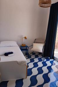 a bedroom with a bed and a blue and white floor at Casa Plemmirio Varco 22 in Plemmirio
