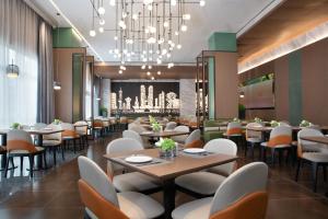 restauracja ze stołami i krzesłami oraz żyrandolem w obiekcie Hilton by Hampton Chengdu North Railway Station w mieście Chengdu