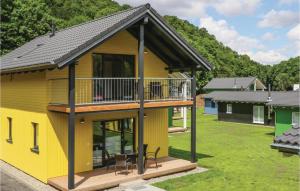 gelbes Haus mit Terrasse und Balkon in der Unterkunft Ferienhausdorf Thale in Thale