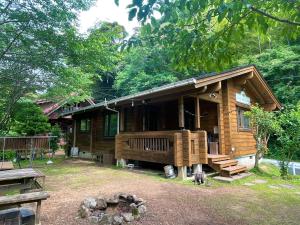 a wooden cabin with a porch and a deck at Sunny Side Cottage in Shimoda