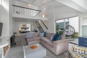a living room with a couch and a bedroom at Herons House in Knysna