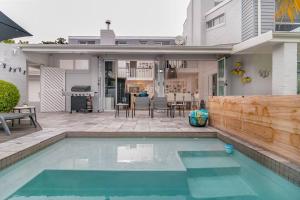 a swimming pool in front of a house at Herons House in Knysna