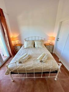 a bedroom with a bed with two lamps on two tables at Casa Luna - Three Bedroom Villa with Stunning View in Benidoleig