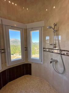 a bathroom with a shower and two windows at Casa Luna - Three Bedroom Villa with Stunning View in Benidoleig