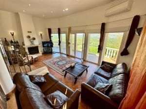 a living room with a leather couch and a table at Casa Luna - Three Bedroom Villa with Stunning View in Benidoleig