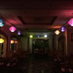 een kamer met tafels en stoelen en kleurrijke verlichting bij Spring Hotel in Can Tho