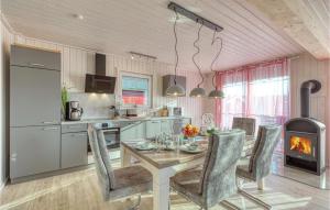 a kitchen with a table with chairs and a fireplace at Gorgeous Home In Zerpenschleuse in Zerpenschleuse