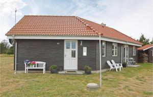 a small house with two white chairs in front of it at Holiday Home Syrenvej Skjern Ix in Skjern