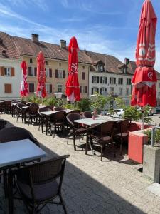 a group of tables and chairs with umbrellas at Hôtel La Fontaine in Saint-Imier