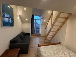 a living room with a couch and a staircase at Duplex sympa Verviers in Verviers