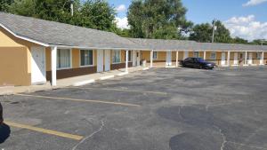 a building with a car parked in a parking lot at Chief Motel in Keokuk