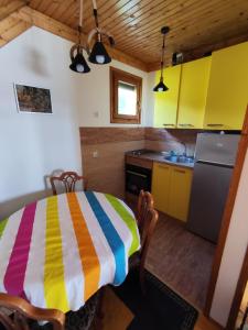 una cucina con tavolo e asciugamano colorato di Queen Suite in Grand Rabbit House a Žabljak
