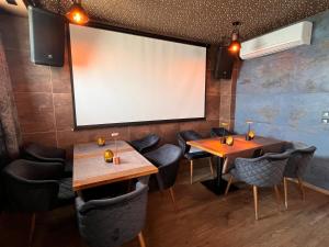 a large screen in a restaurant with two tables and chairs at Pino - Villa, Casa, Cucina е Terrazza in Albena