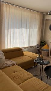 a living room with two beds and a window with blinds at Славянска резиденс - Спокойствие в центъра на Пловдив in Plovdiv