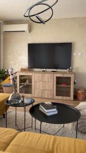 a living room with a tv and a table at Славянска резиденс - Спокойствие в центъра на Пловдив in Plovdiv +15 photos