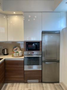 a kitchen with stainless steel appliances and wooden cabinets at Comfy Camel Apartment in Budapest