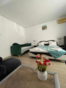 a room with two beds and a vase with flowers in it at Hotel Iulia Resort in Venus