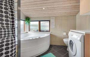 a bathroom with a tub and a washing machine at Holiday Home Sydals With A Fireplace 08 in Neder Lysabild +16 photos