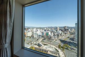 a window with a view of a city at Hotel Associa Toyohashi in Toyohashi