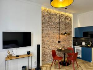 a kitchen and dining room with a brick wall at PRZYSTANEK KATOWICE Mariacka 7 in Katowice