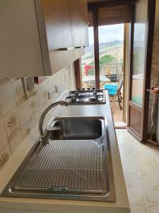 a kitchen with a sink and a stove and a window at La quiete tra le montagne in Apiro