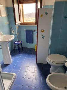 a blue bathroom with a toilet and a sink at La quiete tra le montagne in Apiro +19 photos