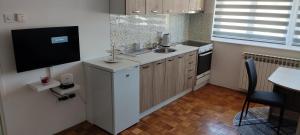 a small kitchen with a sink and a tv at Stan Vogosca in Vogošća