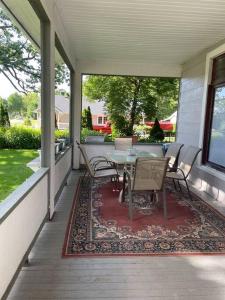 eine Terrasse mit Tisch und Stühlen auf einer Veranda in der Unterkunft 19 century Victorian Home in Des Moines