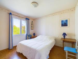 ein Schlafzimmer mit einem weißen Bett und einem Fenster in der Unterkunft Maison avec jardin - Entre plage et rivière in Le Fenouiller