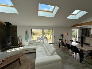 a living room with a white couch and tables and windows at La Roselière - CDDT in Yves
