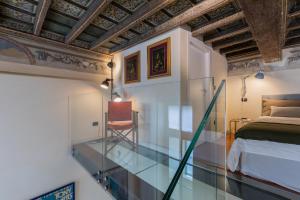 une chambre avec un sol en verre, un lit et une chaise dans l'établissement Casa Savoia by Wonderful Italy, à Turin