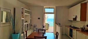 a kitchen and dining room with a table and a view of the ocean at On The Beach SORRENTO in Massa Lubrense +28 photos