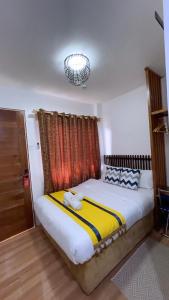 um quarto com uma cama grande e um lustre em Mactan Hostel em Lapu Lapu City